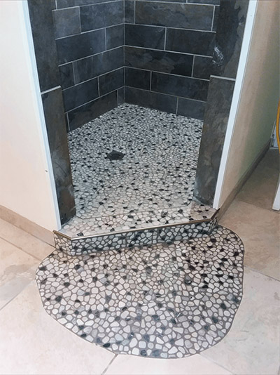 River Rock Tile Installation in bathroom completed by Acorn Maintenance Repair in Eagle River